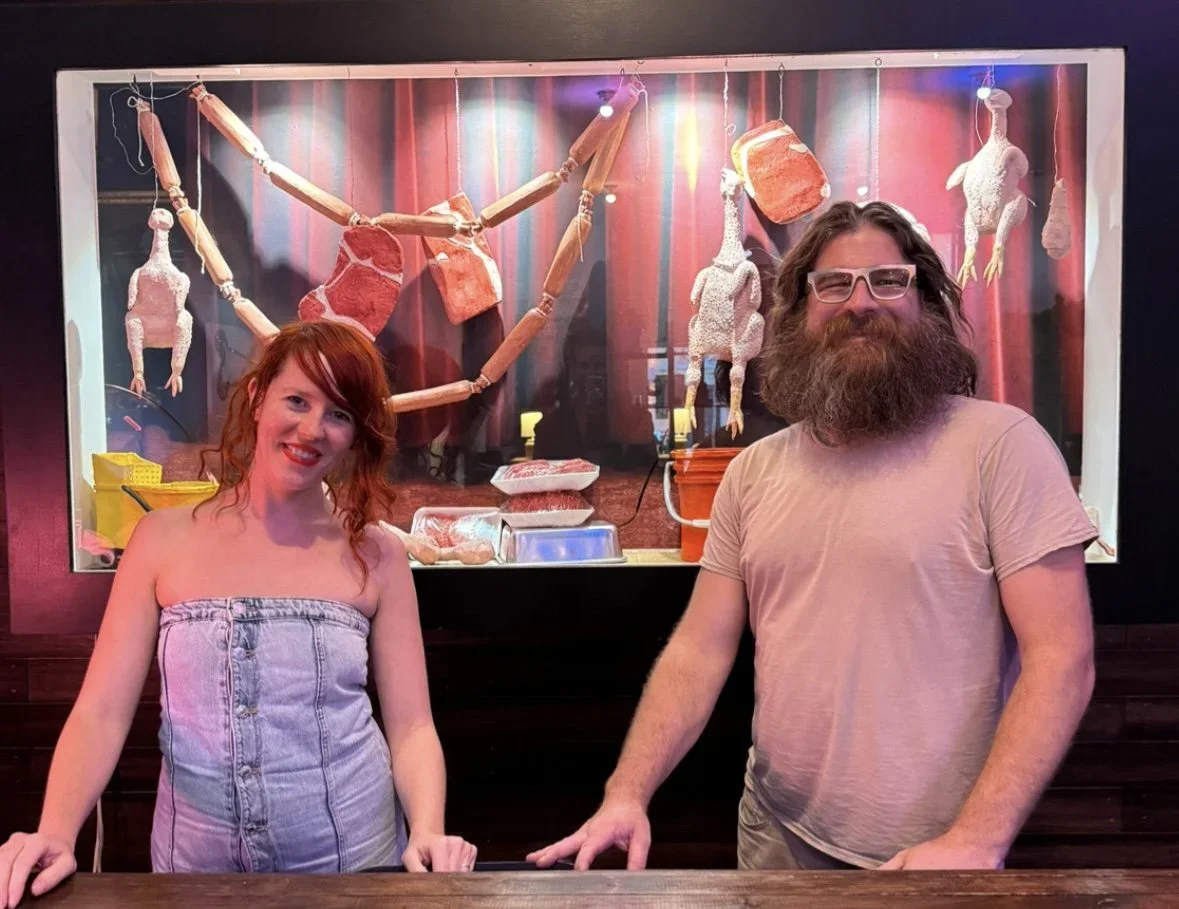 Jen Catron and Paul Outlaw standing in front of their display, "Meat Sweats"