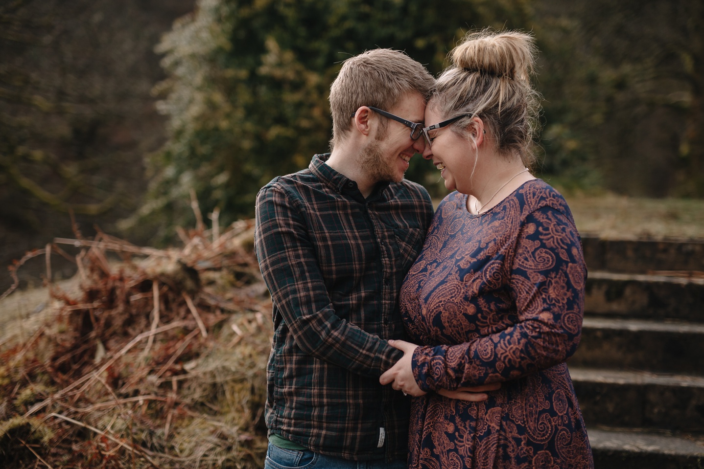 man and woman embracing on the steps of errwood hall