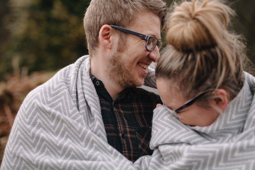 man and woman wrapped in a blanket laughing
