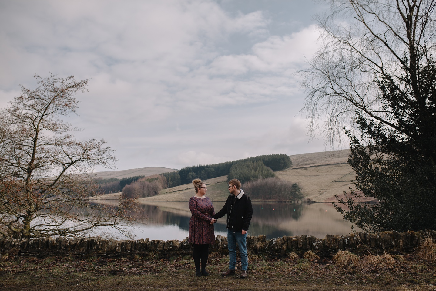 man and woman holding hands infront of eerwood reservoir and the Goyt Valley