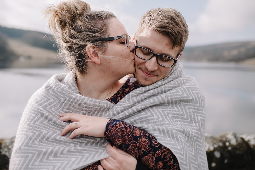 close up of woman kissing man on the cheek