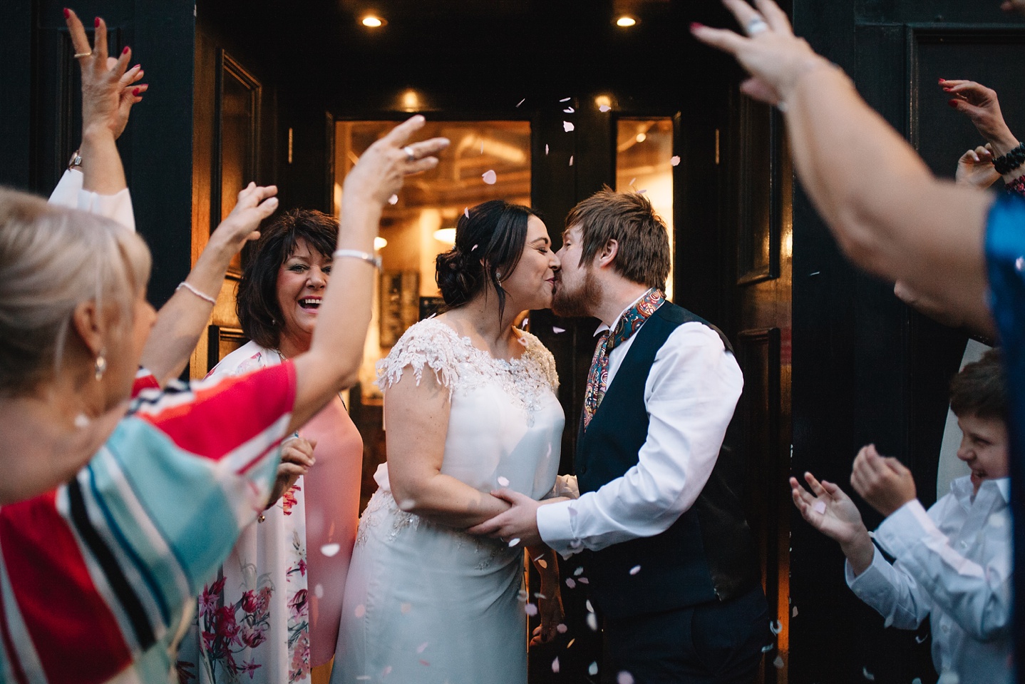 bride and groom kissing outside Couch Sheffield with guests throwing confetti