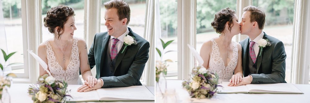 bride and groom signing the register and laughing at Whirlowbrook Hall