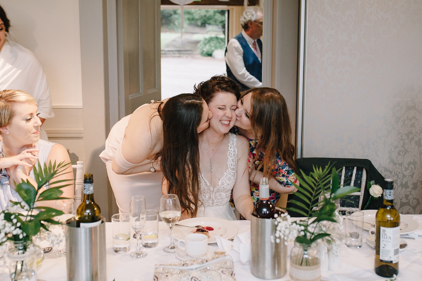 brides friends kissing bride on the cheek during speeches at Whirlowbrook Hall wedding