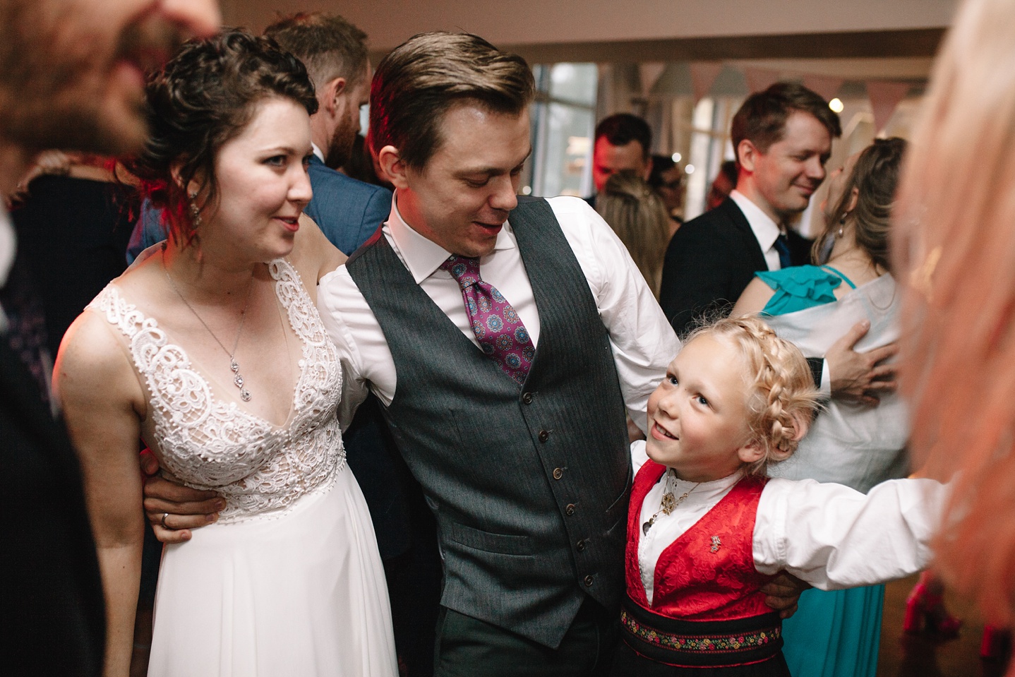 bride and groom dancing with little girl