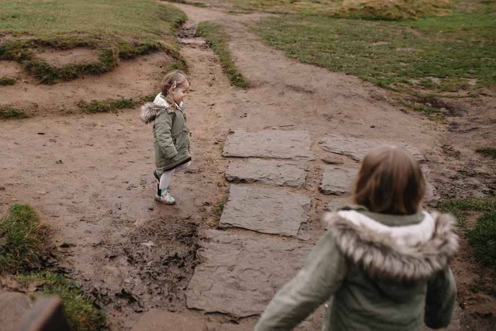 natural family photography or two little girls playing in the mud