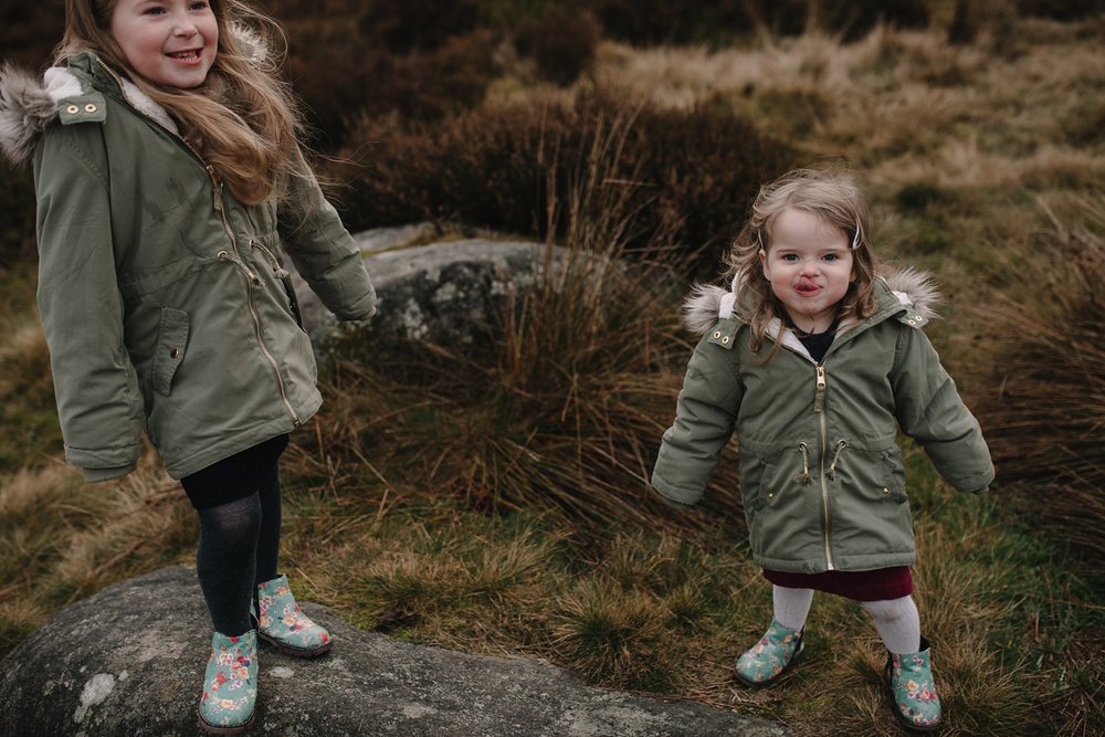 little girl stood sticking her tongue out at the camera