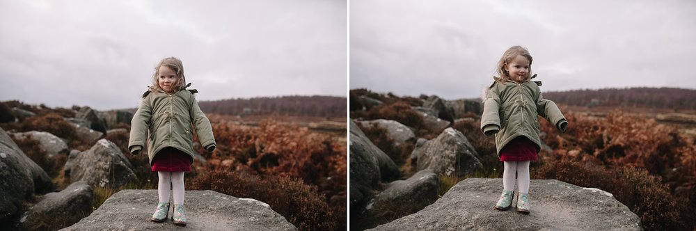 little girl stood on rock laughing