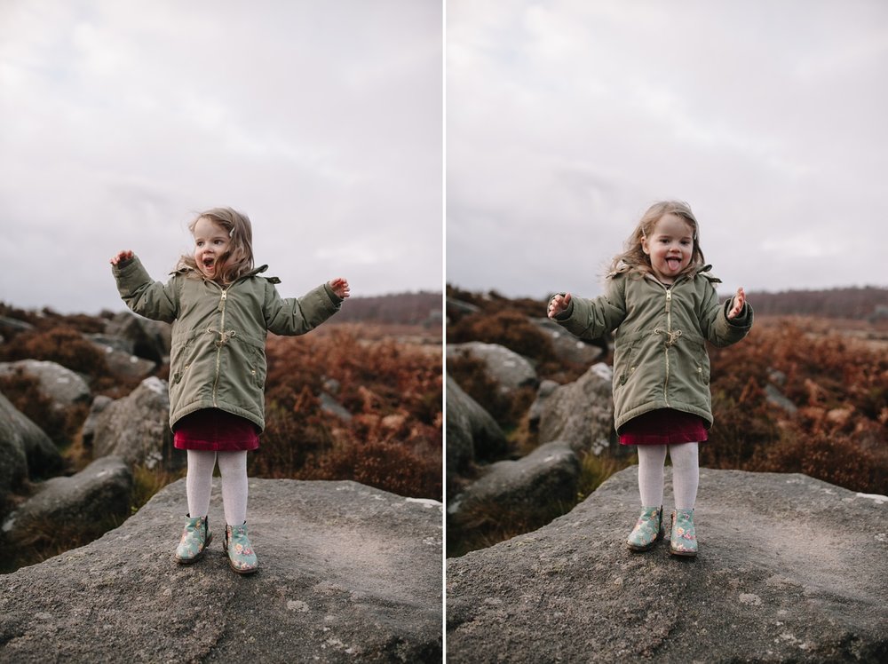 little girl jumping around on a rock smiling and pulling faces