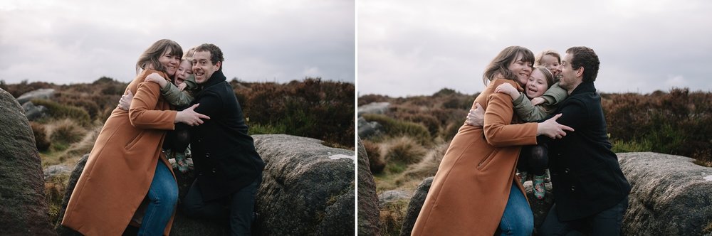 mum, dad and two little girls sat on a rock having a big cuddle