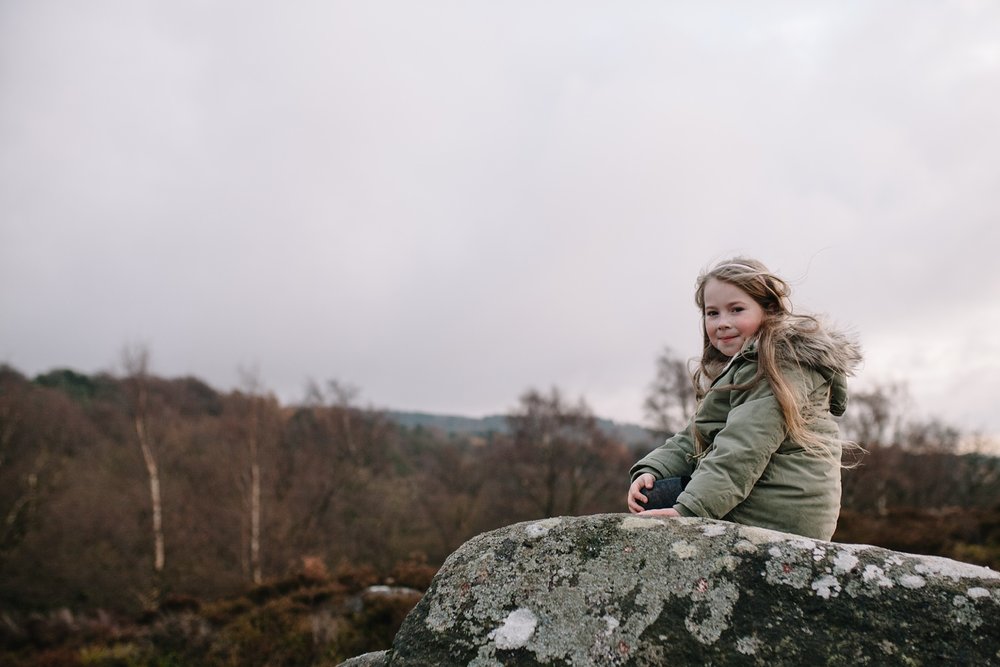 little girl sat on a rock 