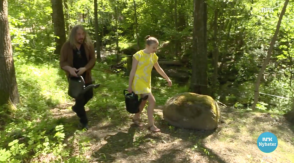 Håvard og Linnea vanner gressfrø på tomta.