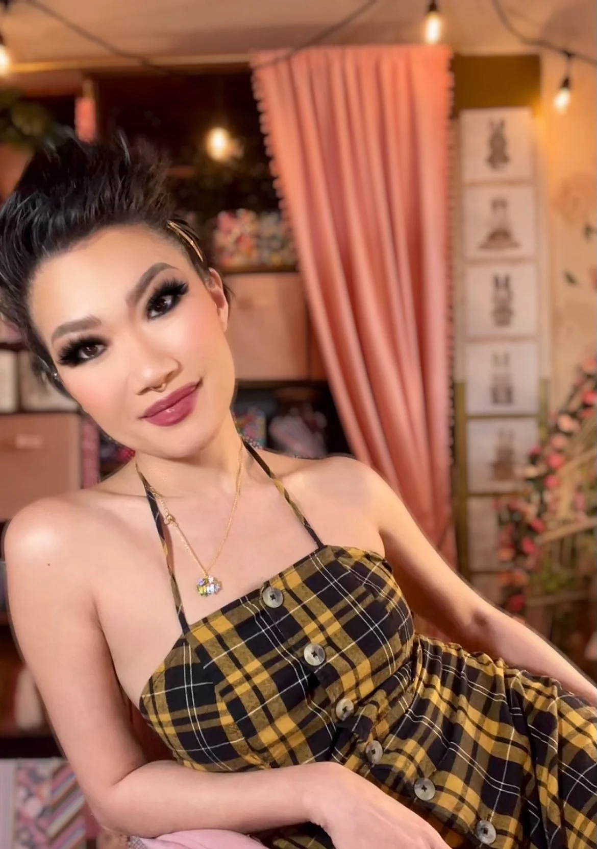 person in a gingham dress in a pink room