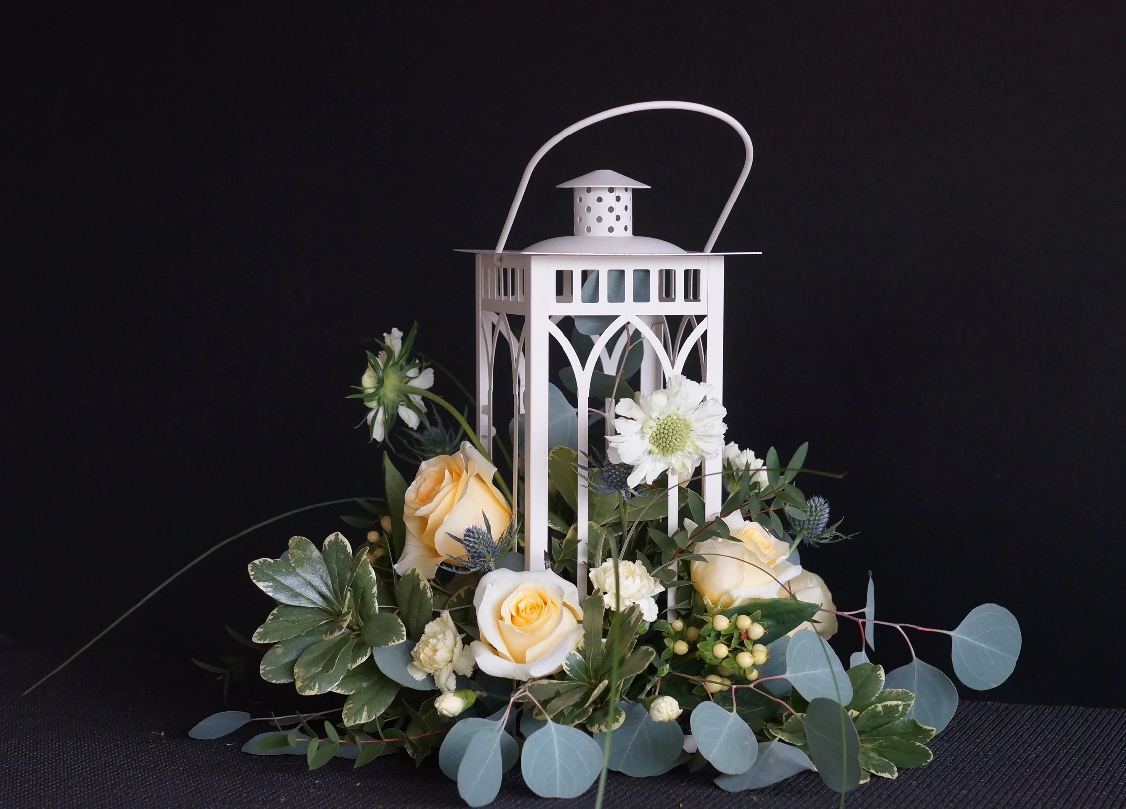 A simple lantern was the base for this combination of blossoms in colors that will glow when the light go down - we filled the lantern with fairy lights for the event.
