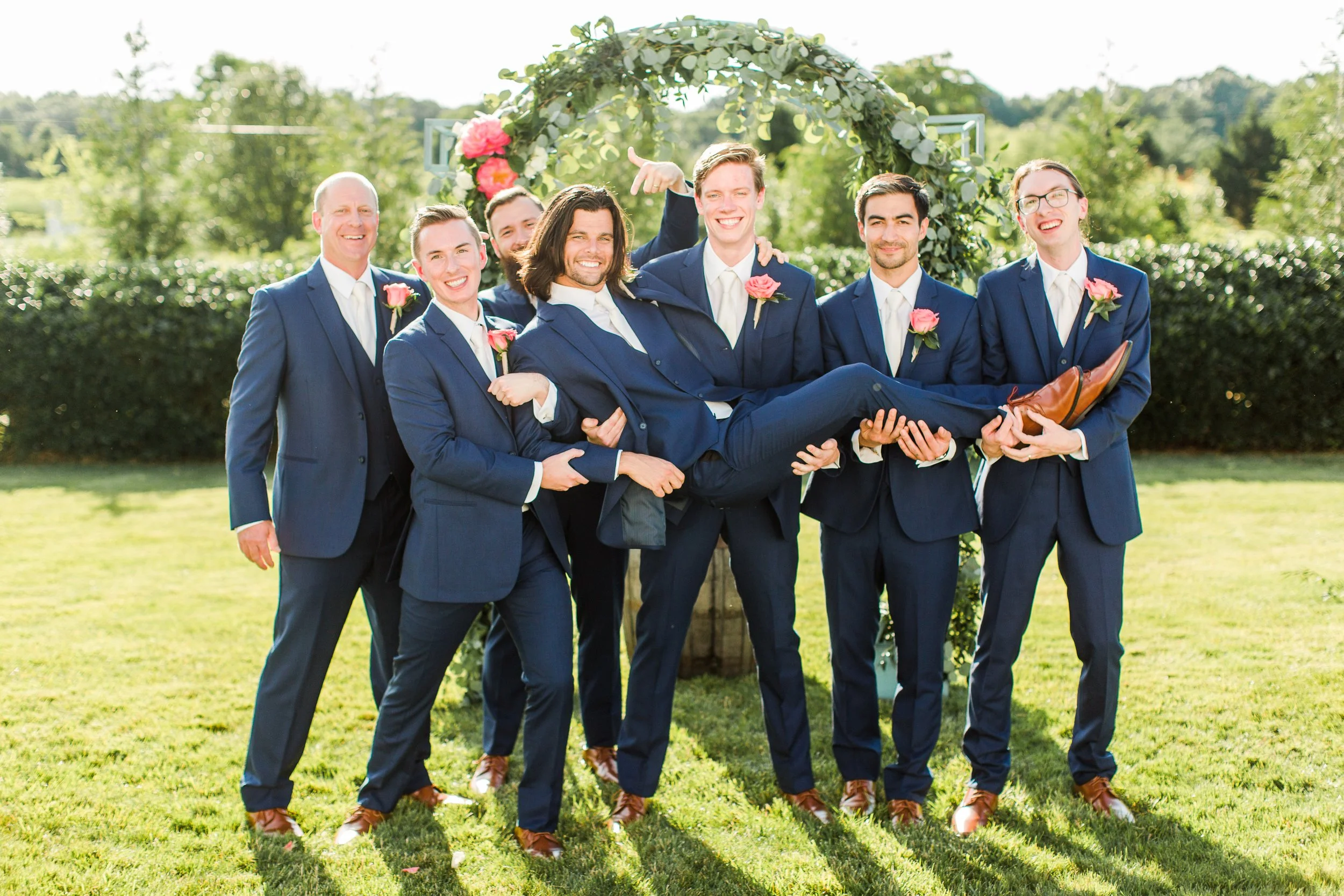 groom being held up by groomsmen.jpeg