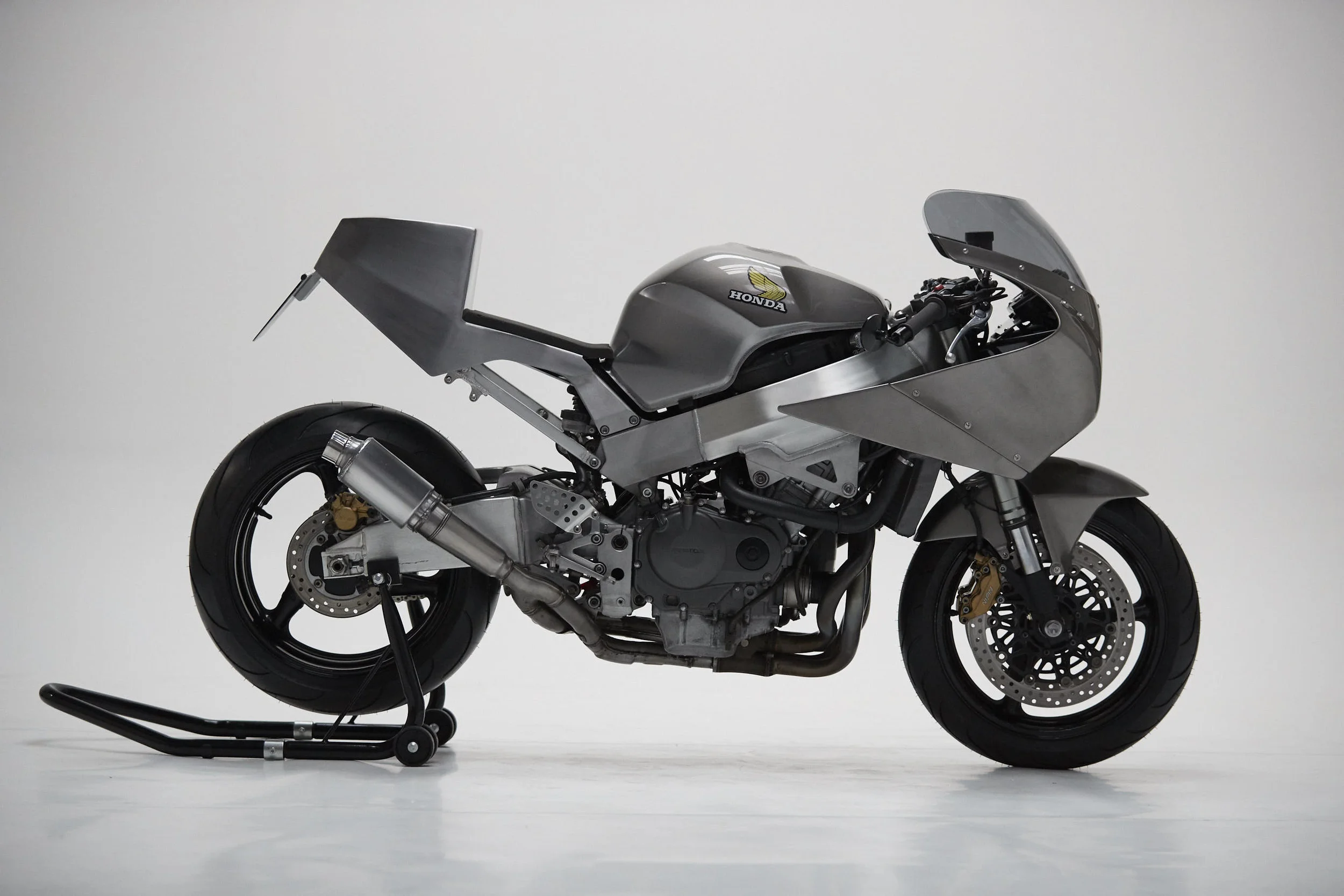 Build Specifications : Daytona 1200 front fairing Modified Triumph Daytona 1200 fairing stay ‘Slip Screens’ fairing screen Fabricated aluminium instrument holder Koto Headlight Fabricated aluminium side fairings Fabricated aluminium ‘stubby’ exhaust muffler Modified Honda Fireblade CBR 929 rear subframe Fabricated aluminium under tray incorporating battery holder, ECU , wiring loom and Regulator/Rectifier. Fabricated steel rear tail/seat unit Race foam seat Fabricated aluminium number plate mount Two tone - exposed steel and painted petrol tank Front fork integrated turn signals LED rear light and integrated turn signals For availability and price please contact.