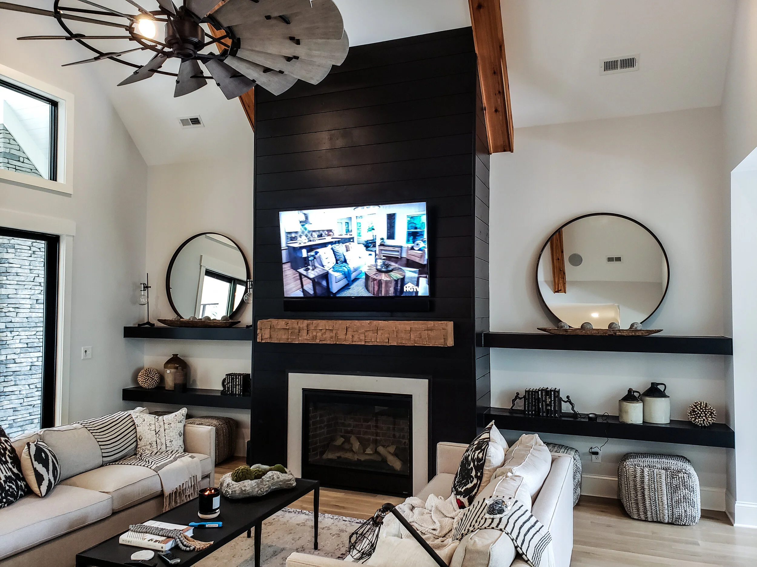 Custom family room built in with floor-to-ceiling shelving and black shiplap cabinets installed by NC Visionz.