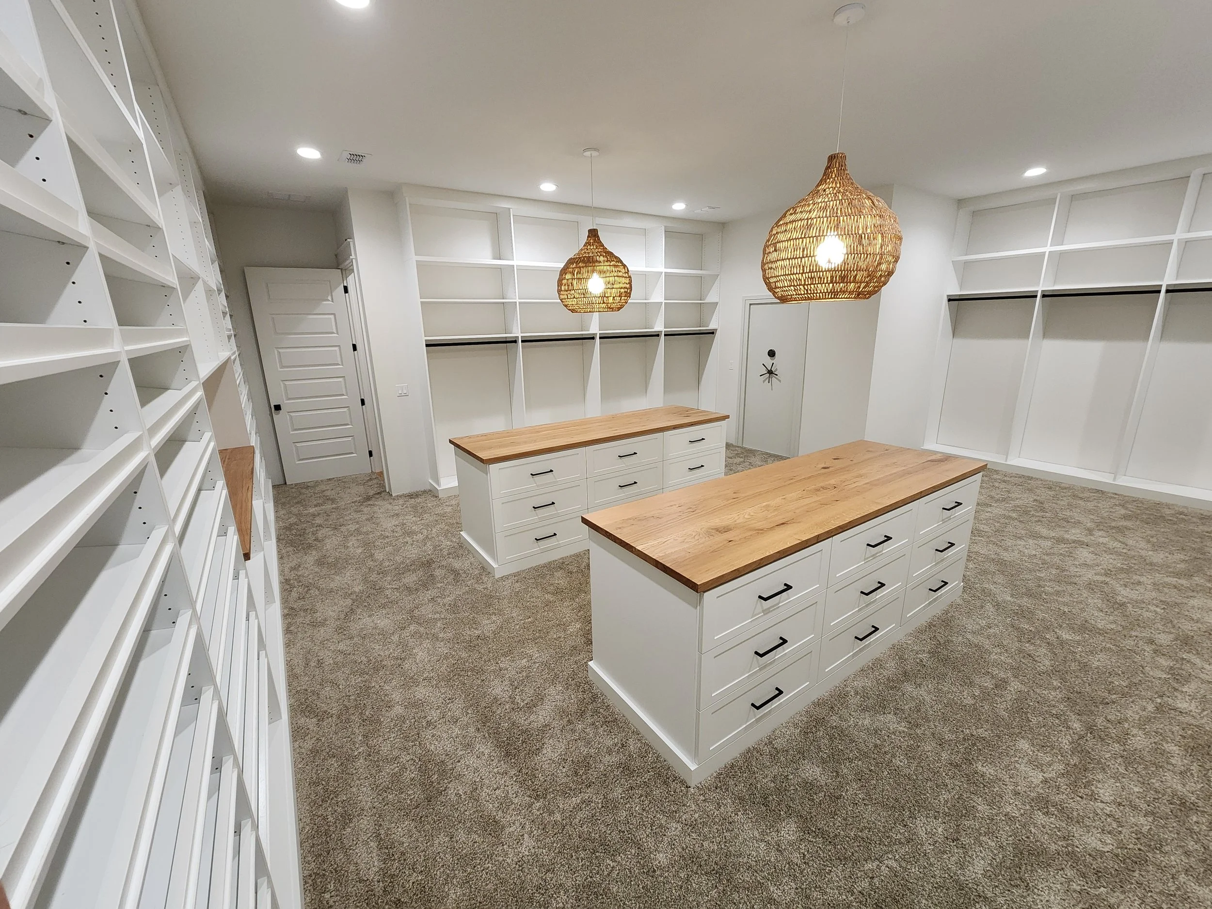 Custom master walk-in closet with center island, built-in drawers, and glass-front cabinets designed and installed by NC Visionz in Denver, NC.