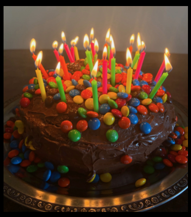 M&M covered chocolate cake with lit birthday candles