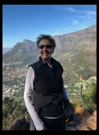 Sheila in South Africa a green view of mountainous valley behind her