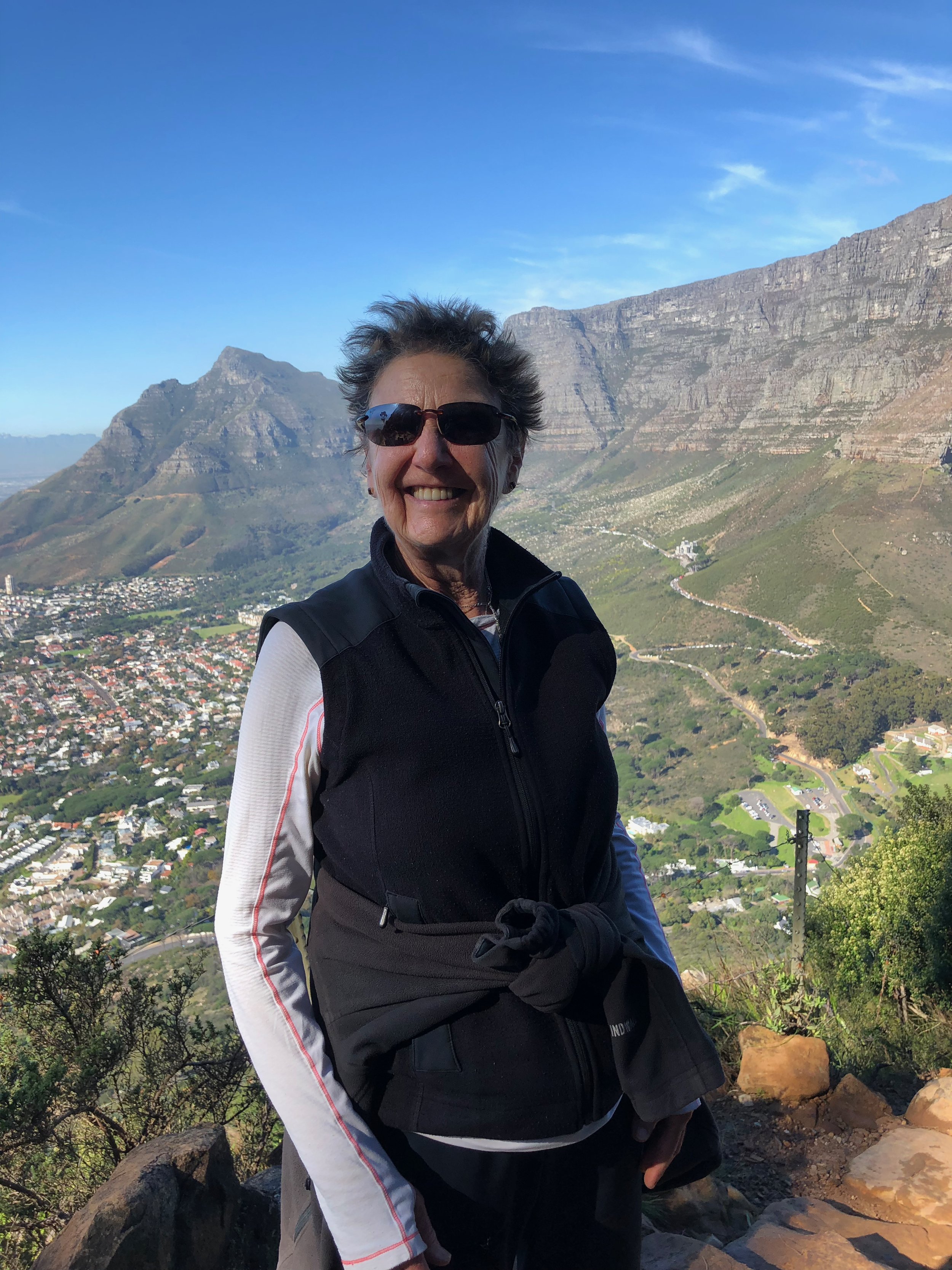Sheila in South Africa a green view of mountainous valley behind her