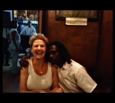 Sheila laughing with a beautiful man hugging her side