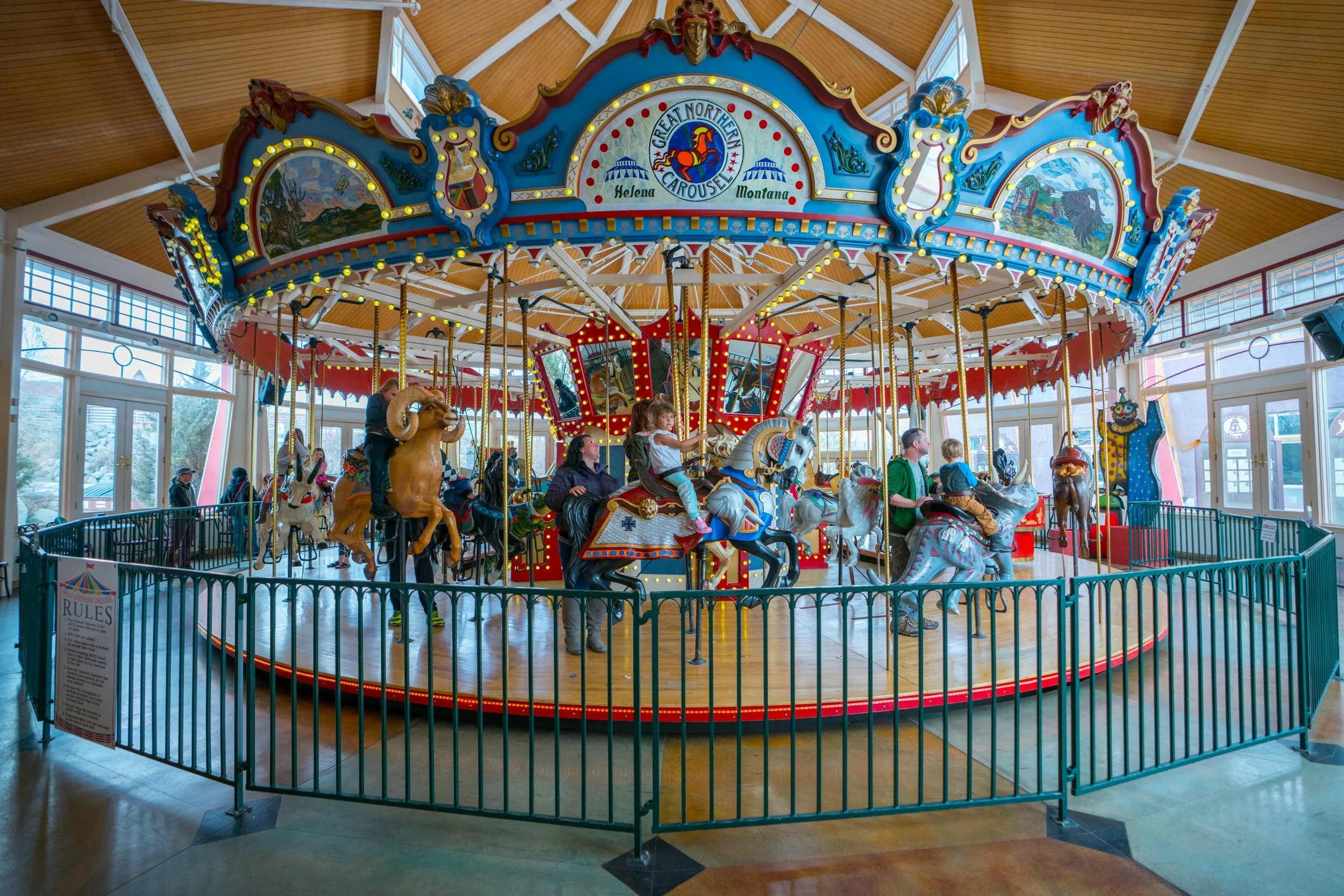 Hand-carved carousel animals beneath the wooden pavilion at Great Northern Carousel