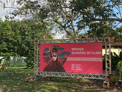 "A space for climate guardianship"—a backdrop poster of ANMIGA at the federal university hosting the "COP village," which housed a dedicated camp for Indigenous peoples.