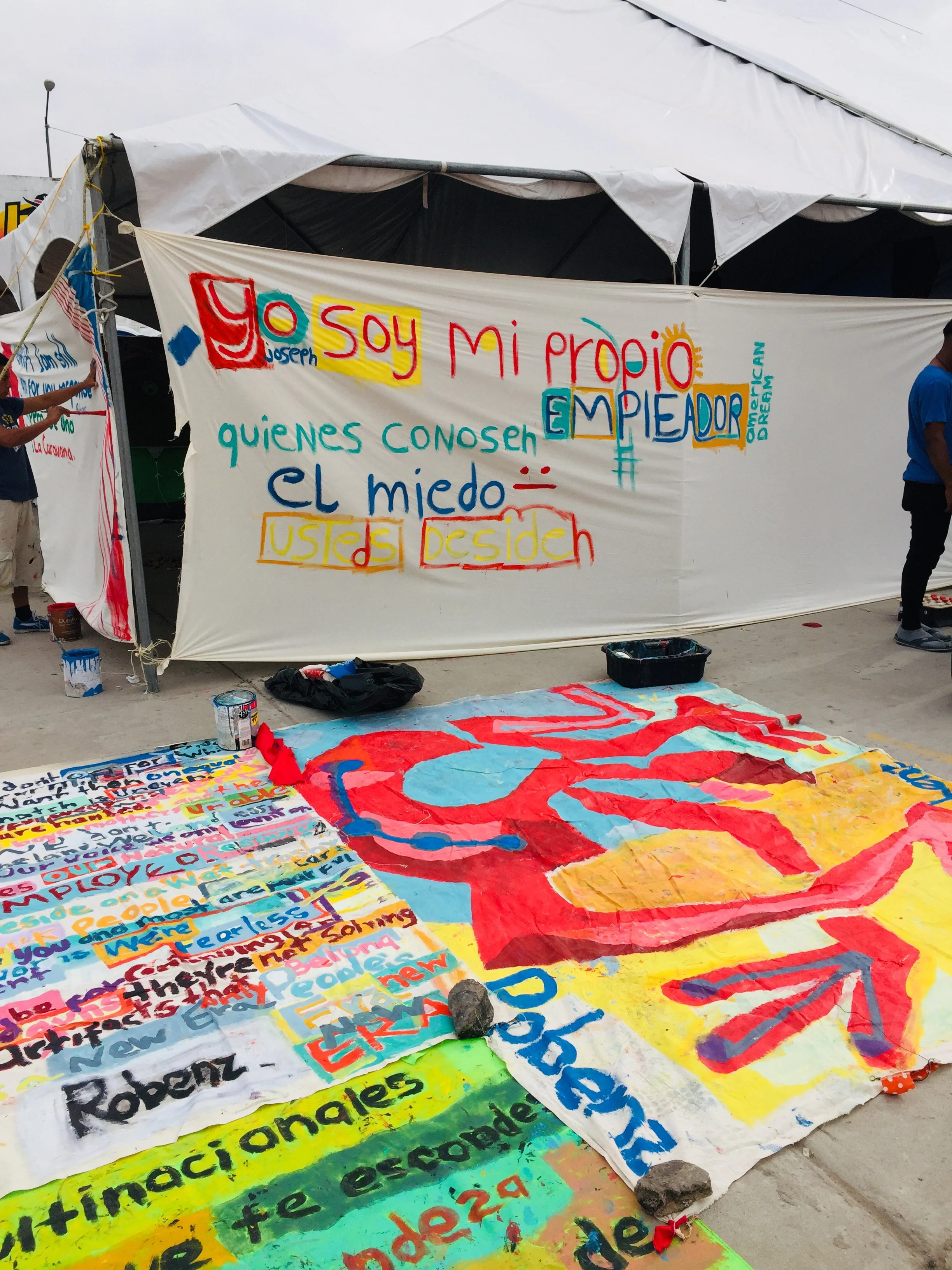 Signs being painted by migrants in the camp