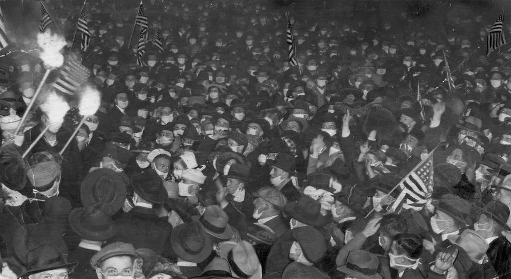 San Francisco residents celebrate the end of World War I on Nov. 11, 1918 with banners and torches and surgical masks.