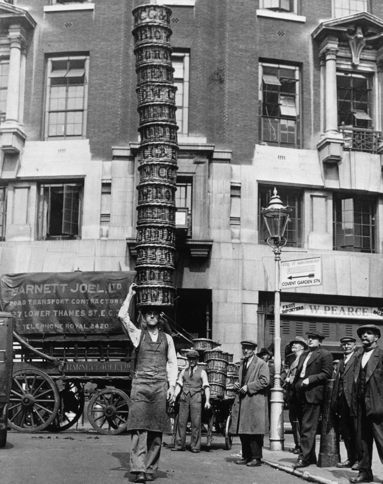  1925: Market trader Alfred Bailey practising with 15 baskets at Covent Garden, London, for the basket-carrying championships. 