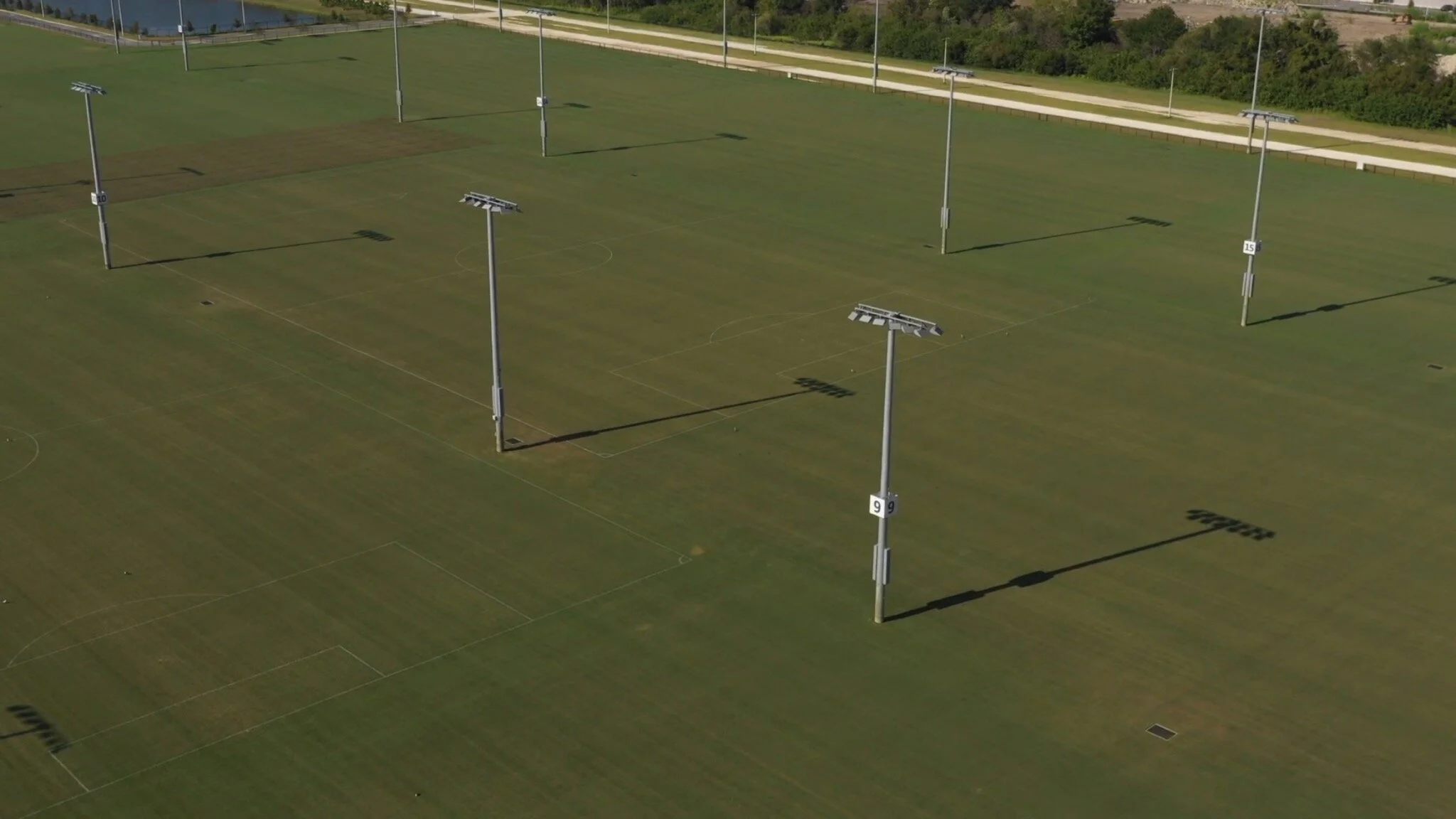 A tight crop of the fields with stadium lights are seen from an ariel view. 