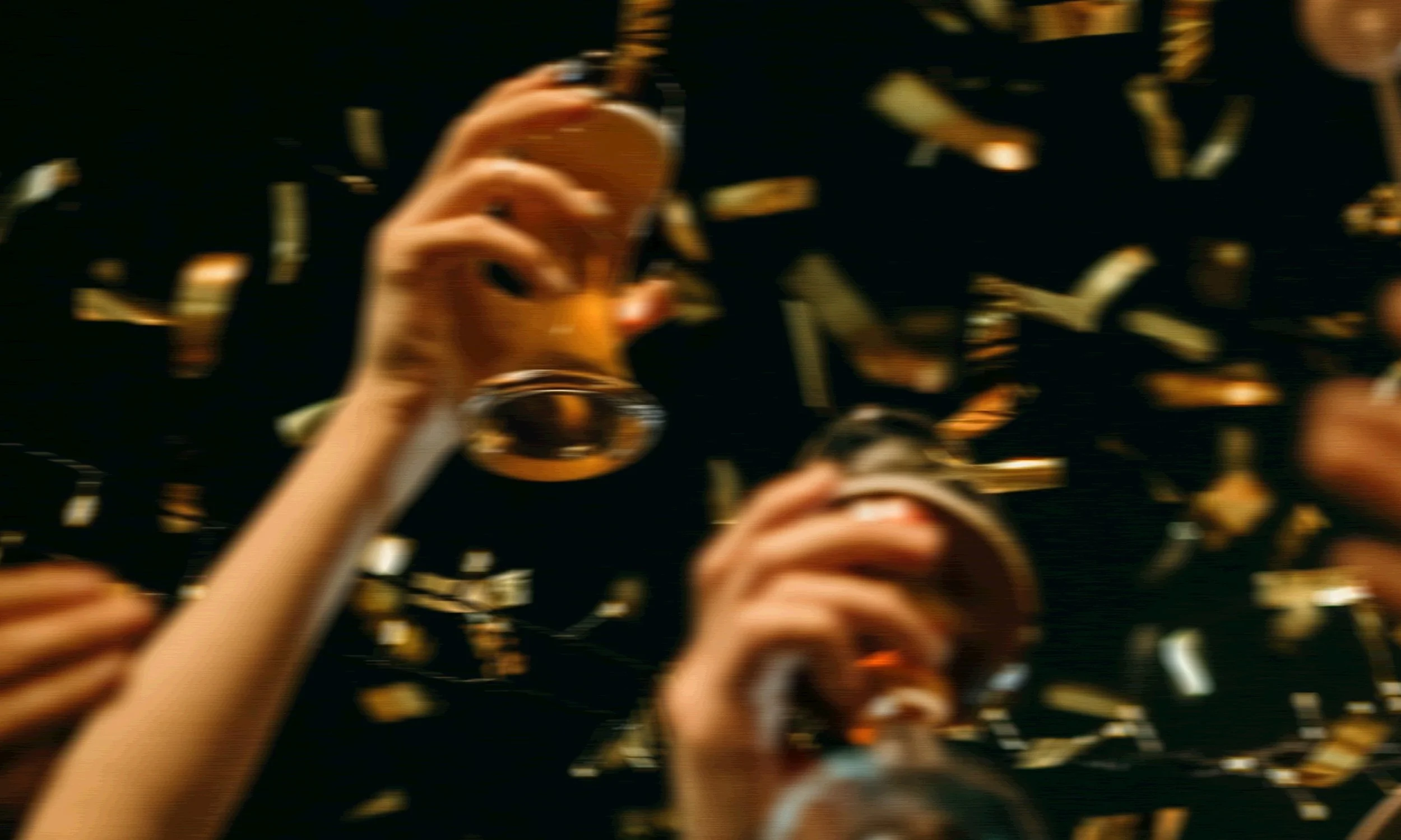 People raising glasses with confetti around them