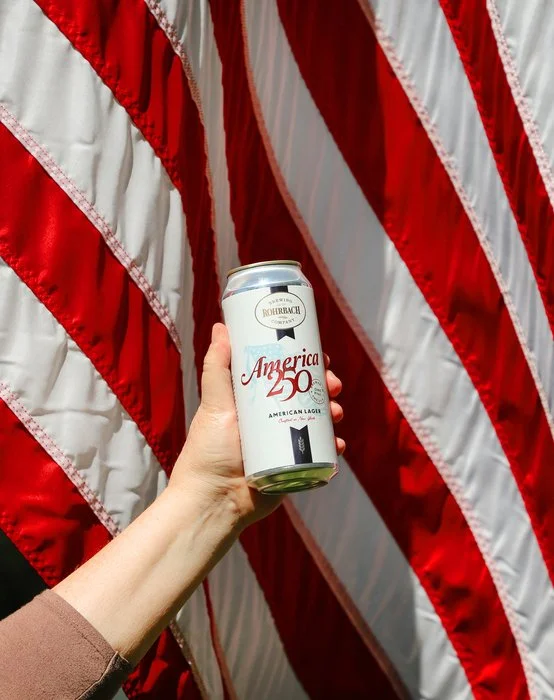 Can of Rohrbach America 250 beer held up in front of an American flag