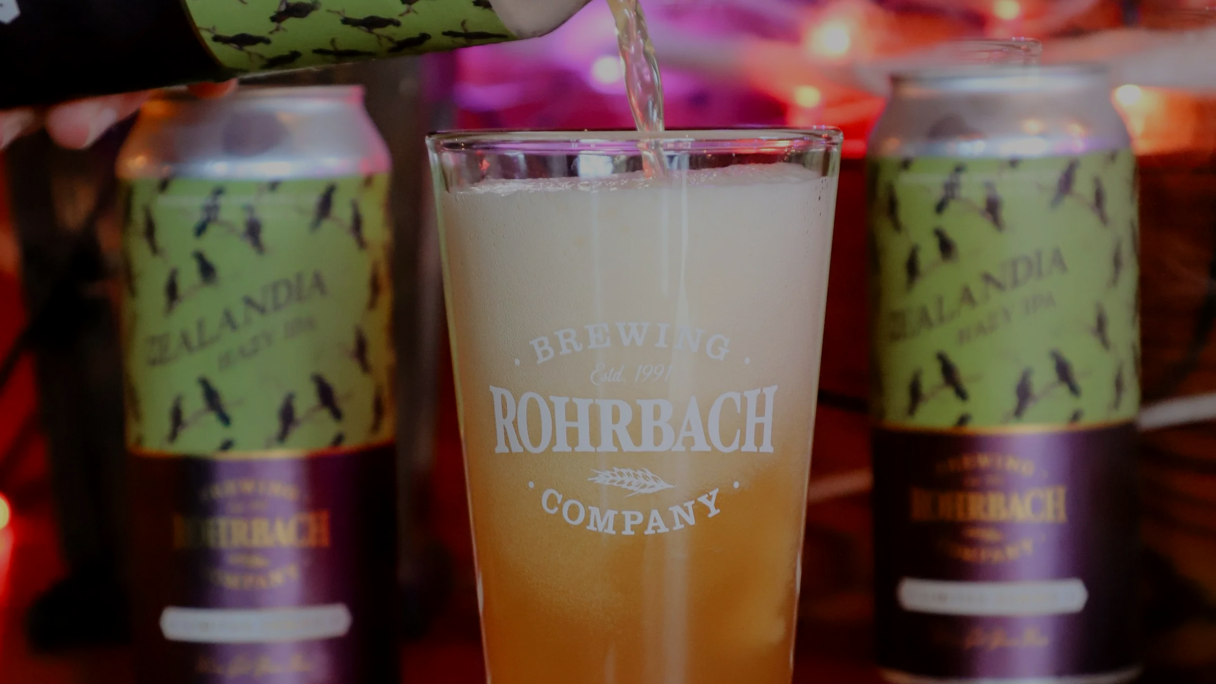 Rohrbach Zealandia Hazy IPA is poured into a pint glass surrounded by Halloween decorations.