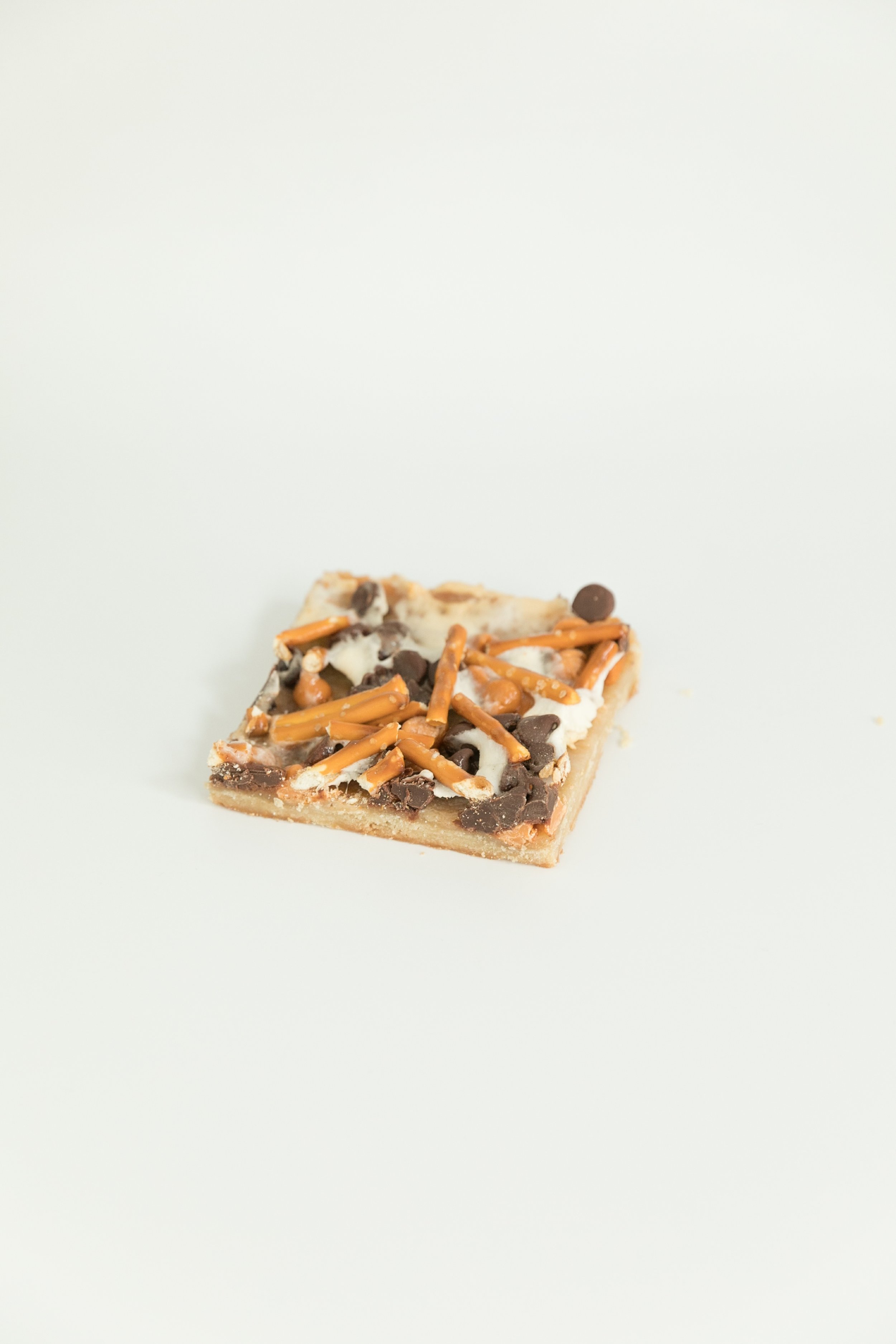  pizza bars topped with pretzels, white chocolate chips, chocolate chips, marshmallows and a cookie bottom.  