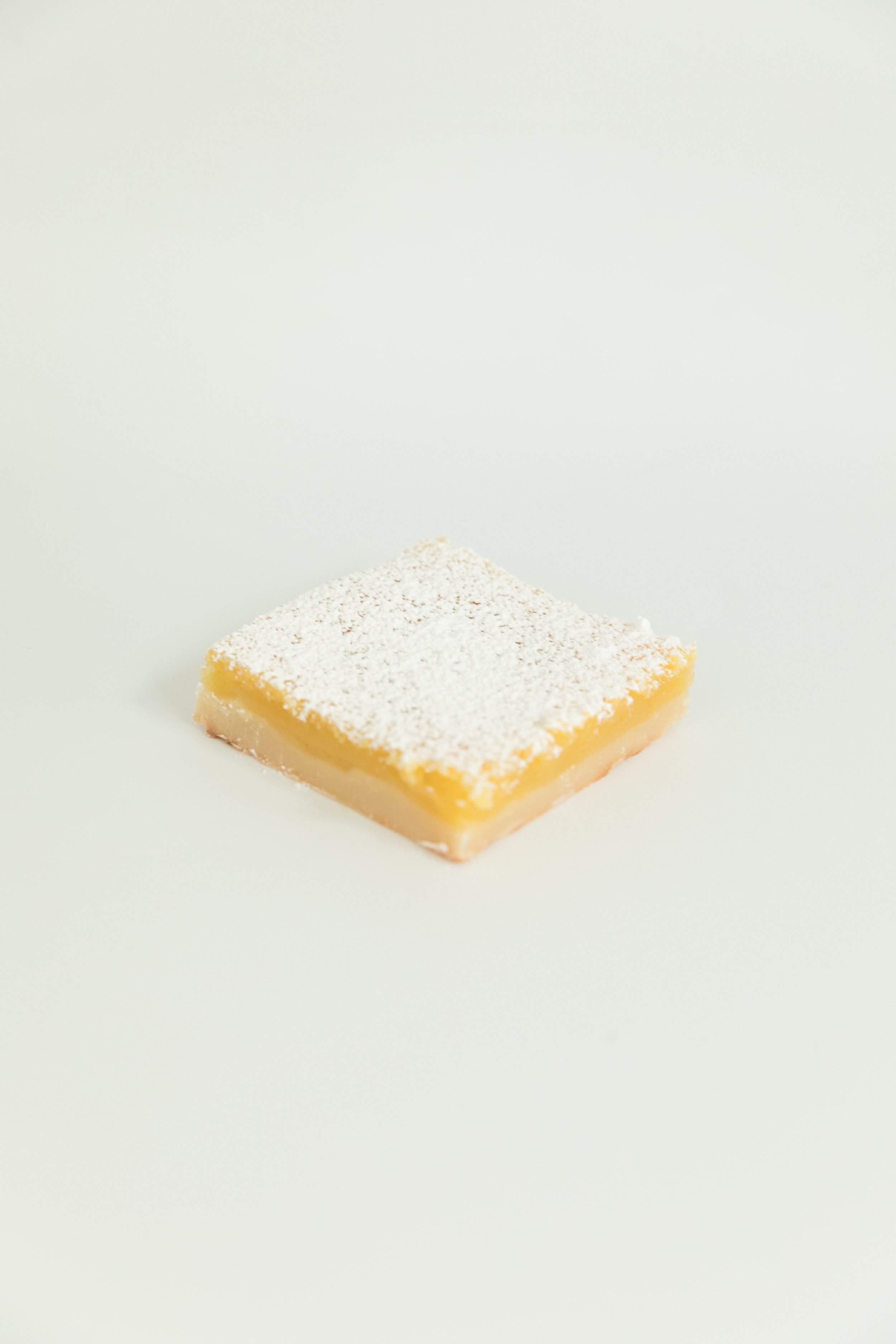  lemon bar topped with a powdered sugar sprinkle 
