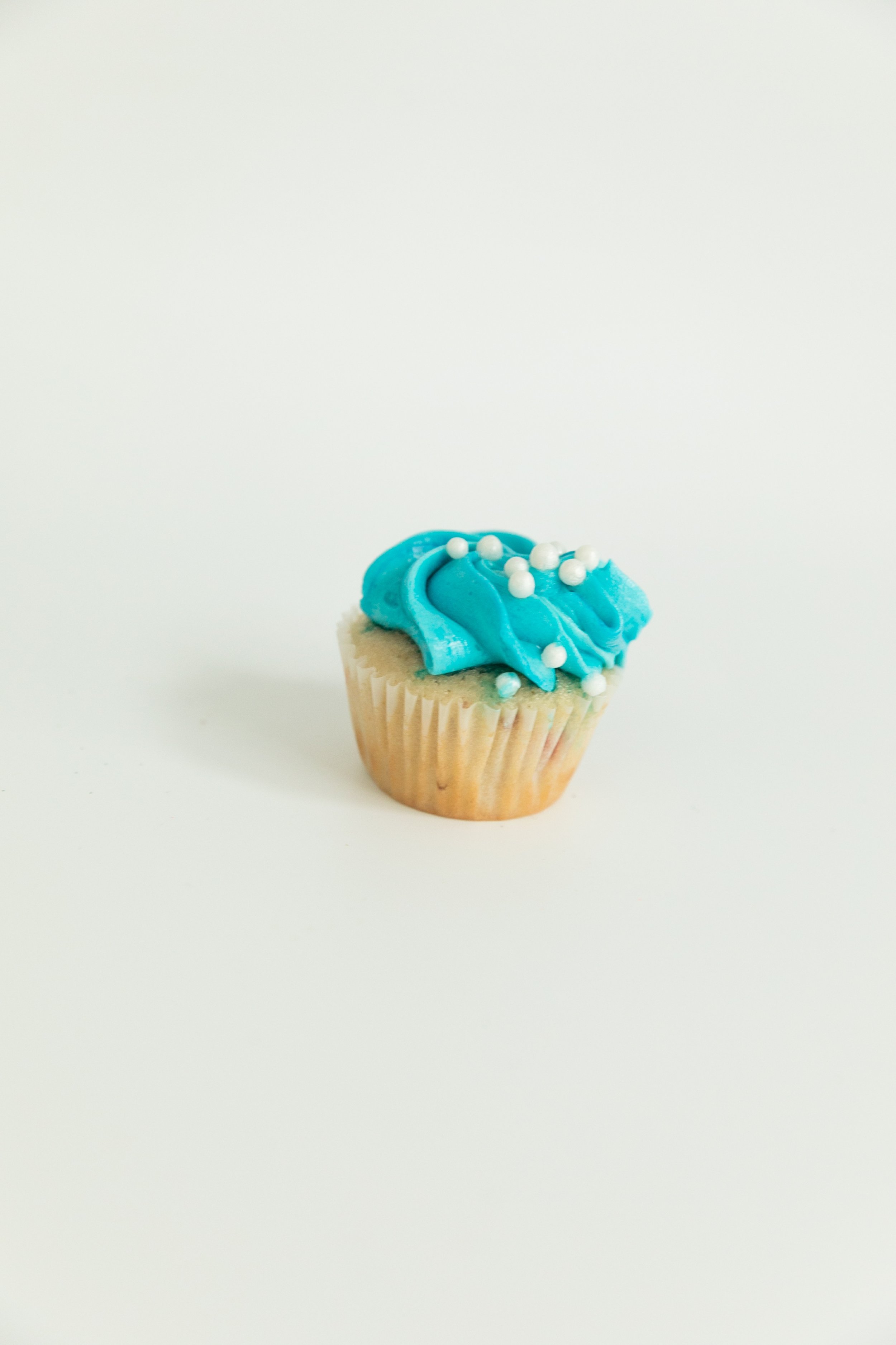  vanilla cupcake with blue vanilla buttercream and pearl sprinkles  