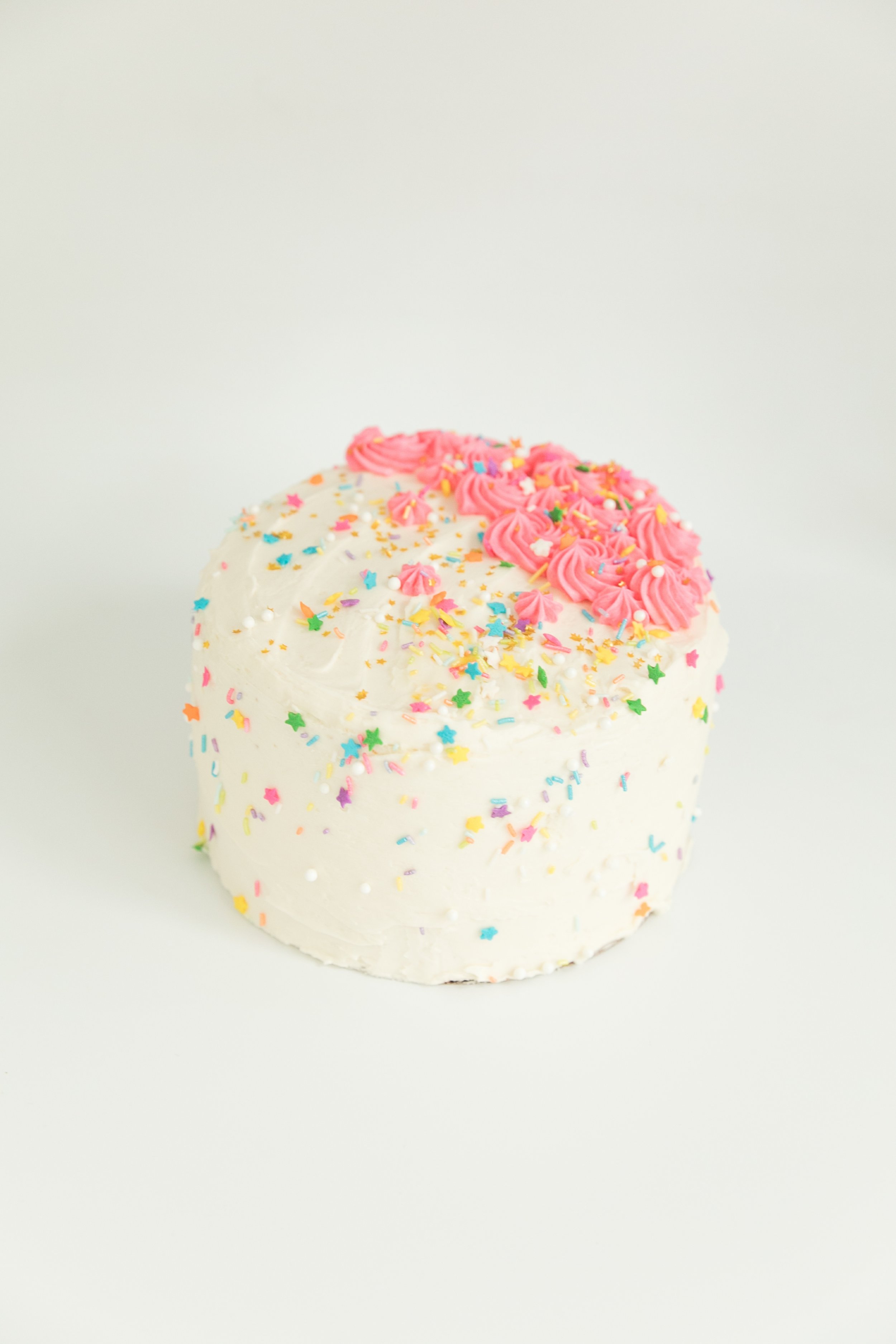  6 inch funfetti cake with sweetapolita sprinkles and pink stars made from vanilla buttercream.  
