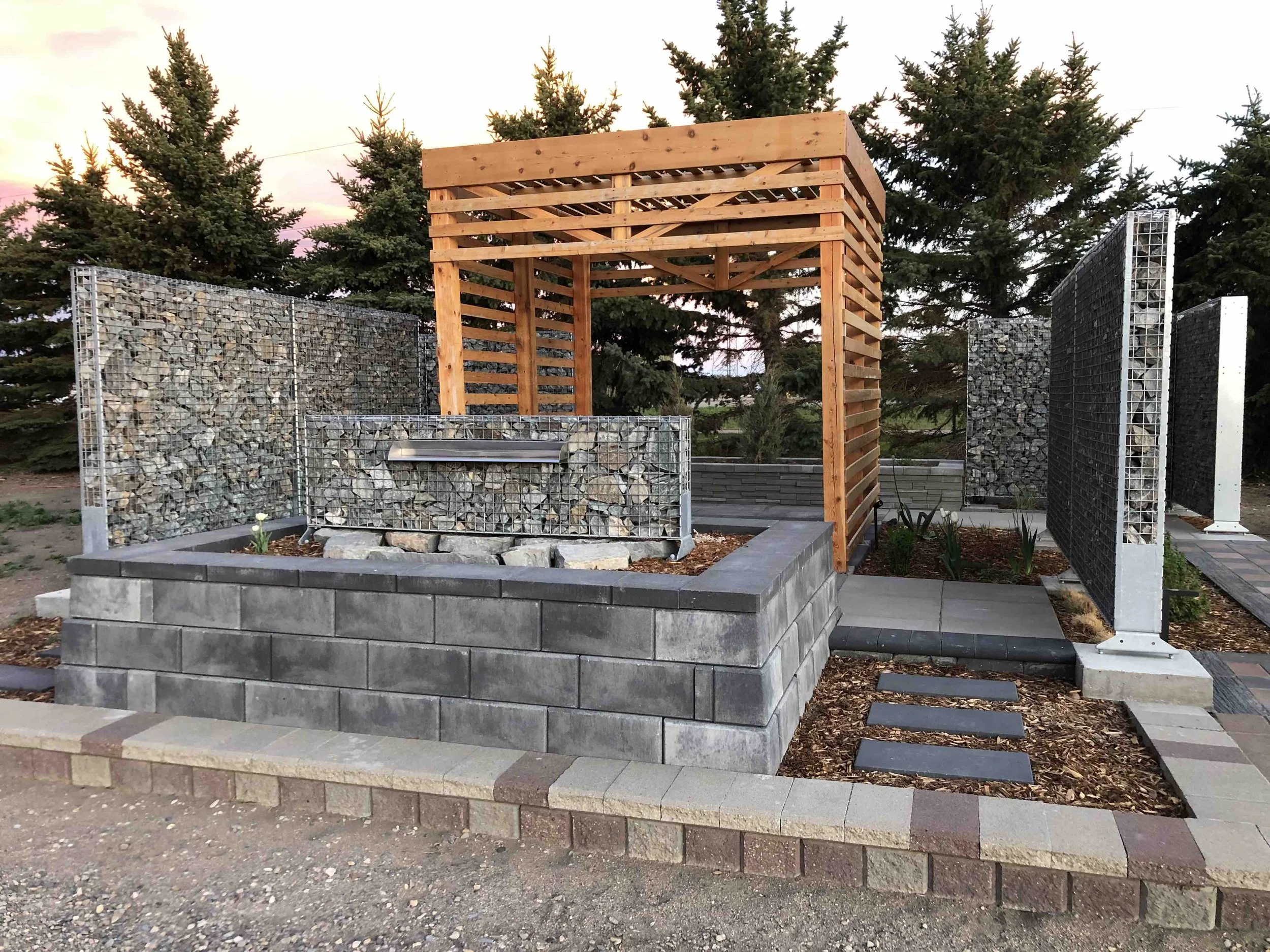 A custom cedar pergola stands out against grey handscaping and evergreen trees