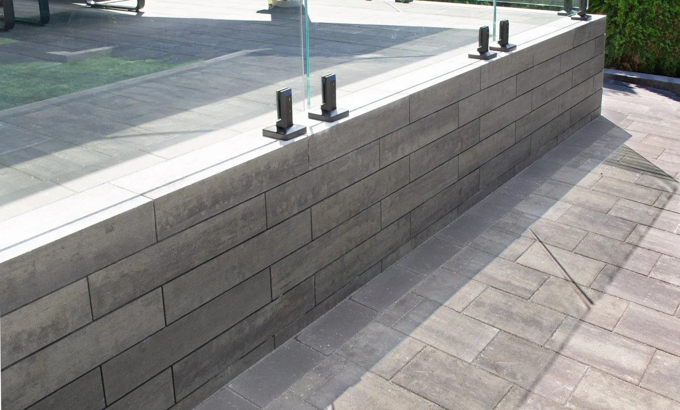 A garden wall provides separation between hardscaping and lawn to create zones in a yard.