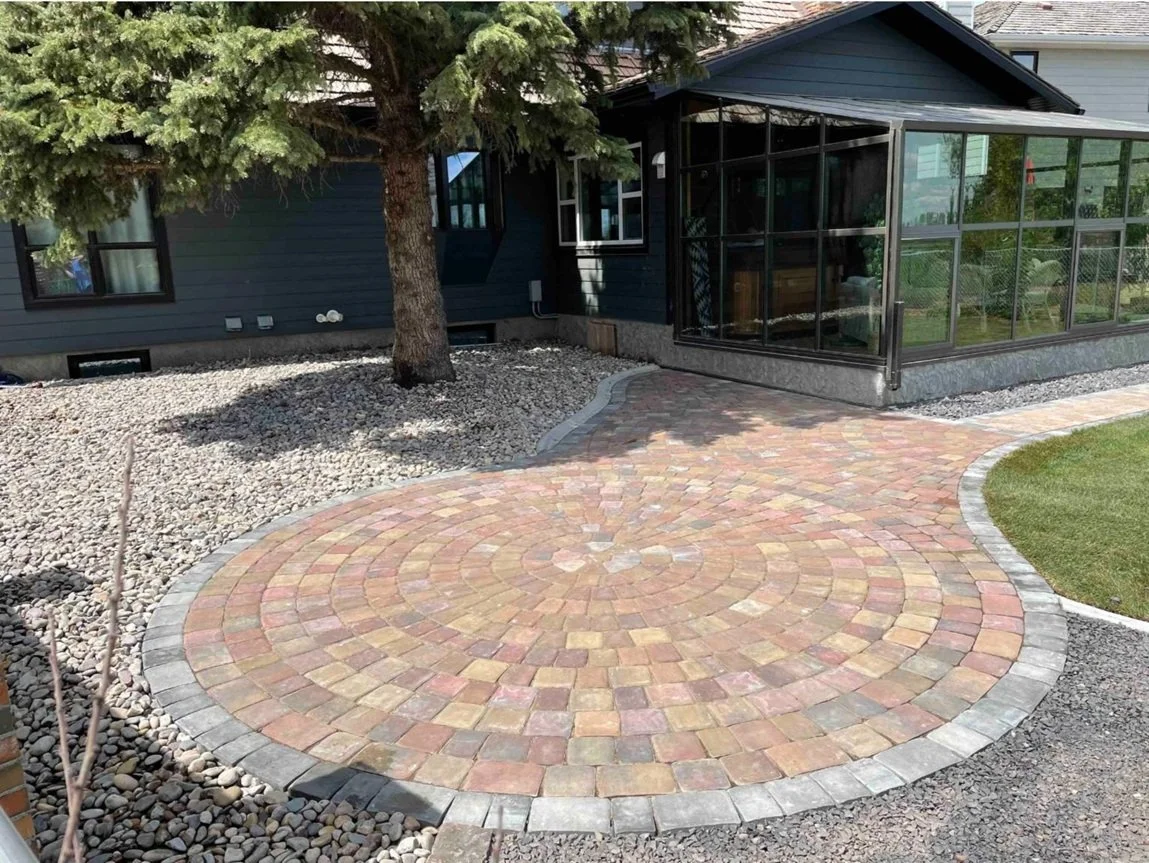 A circular paver patio in contrasting stone colours is a beautiful and functional backyard addition.