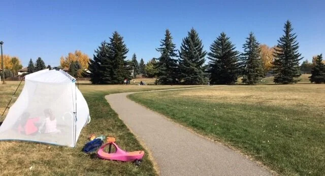 The children in the out-of-school day care program practice safe physical distancing while playing outside.