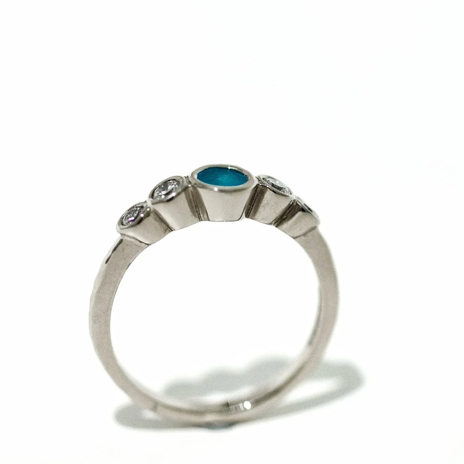 Side view of five stone sea glass and diamond engagement ring on white background