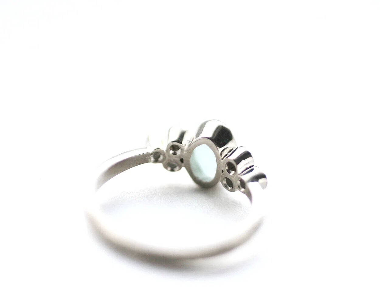 Back view of a sea glass engagement ring showing the open setting behind the stones