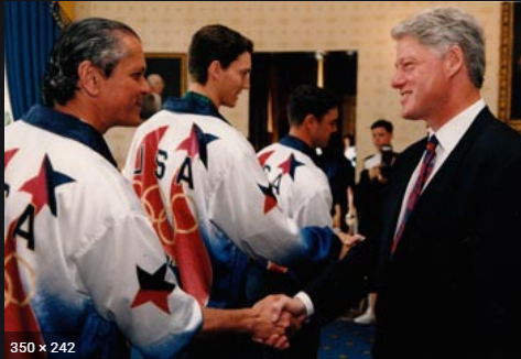 Carl Borack (left), Captain of the US Olympic Fencing Team, shakes hands with Bill Clinton
