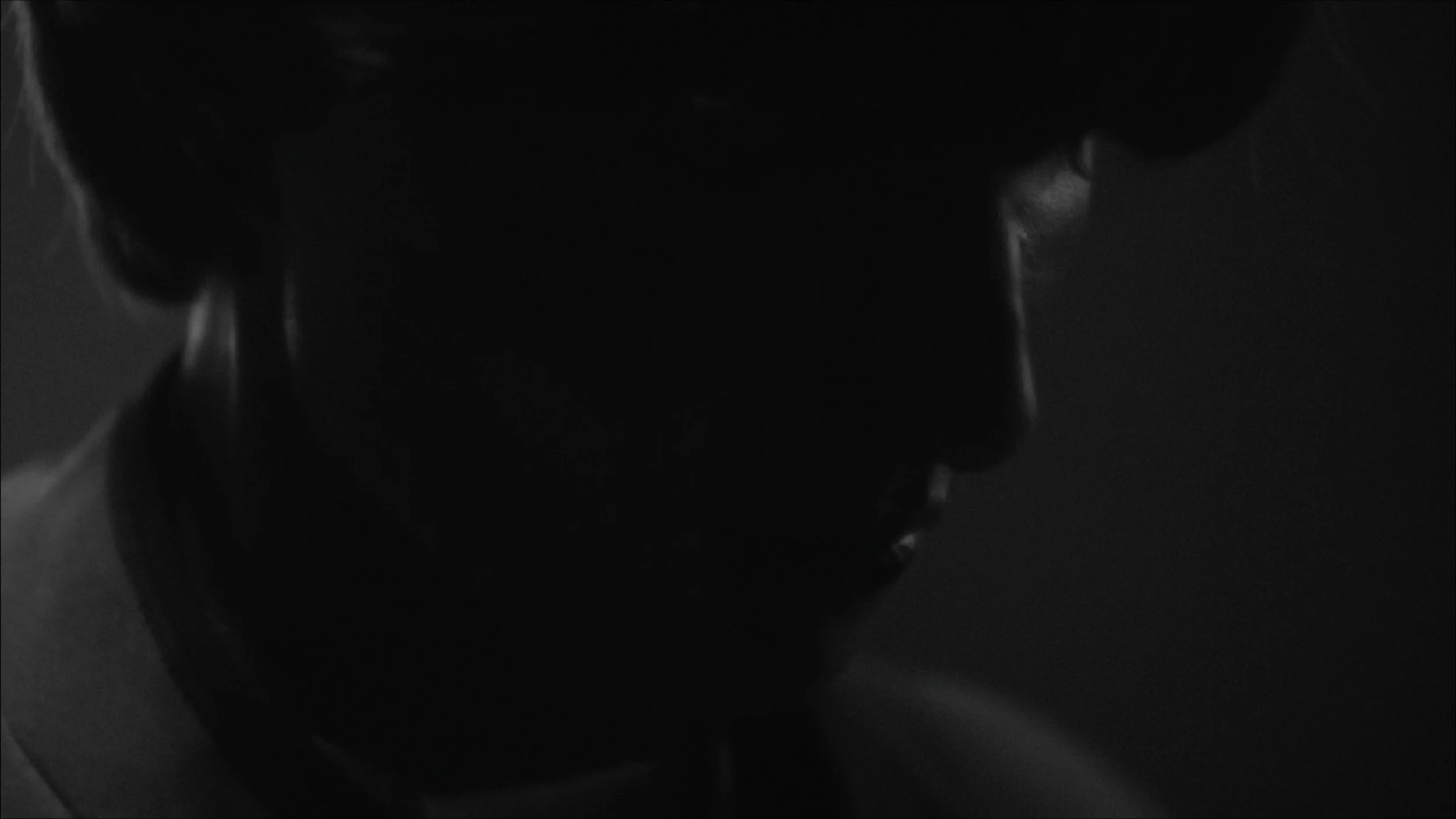 Black-and-white silhouette of a person's head and shoulders facing left against a dark background.