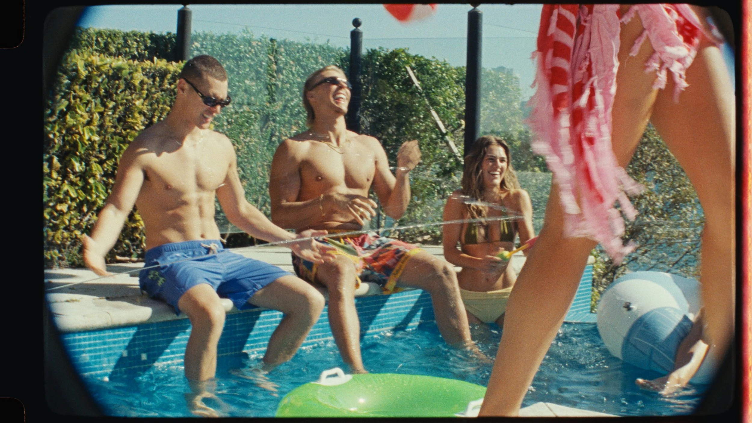 Sunlit poolside scene with young women relaxing on loungers, cinematic tequila lifestyle commercial shot on film by Sydney cinematographer Elliott Deem