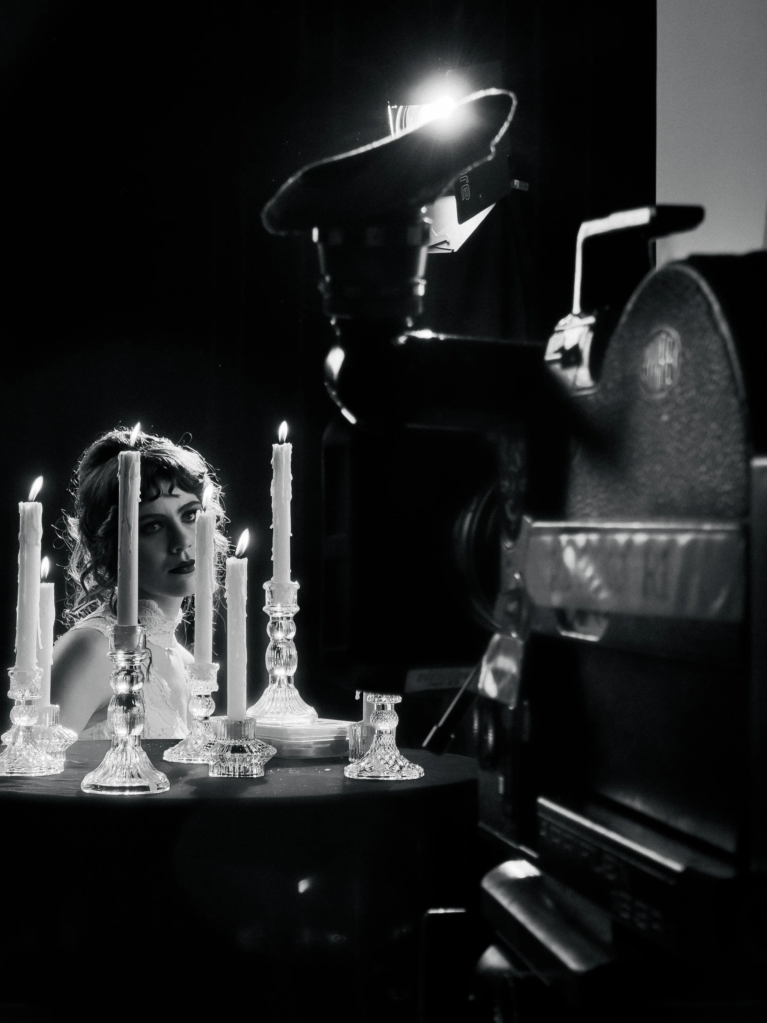 Performer in front of 16mm camera in candlelight