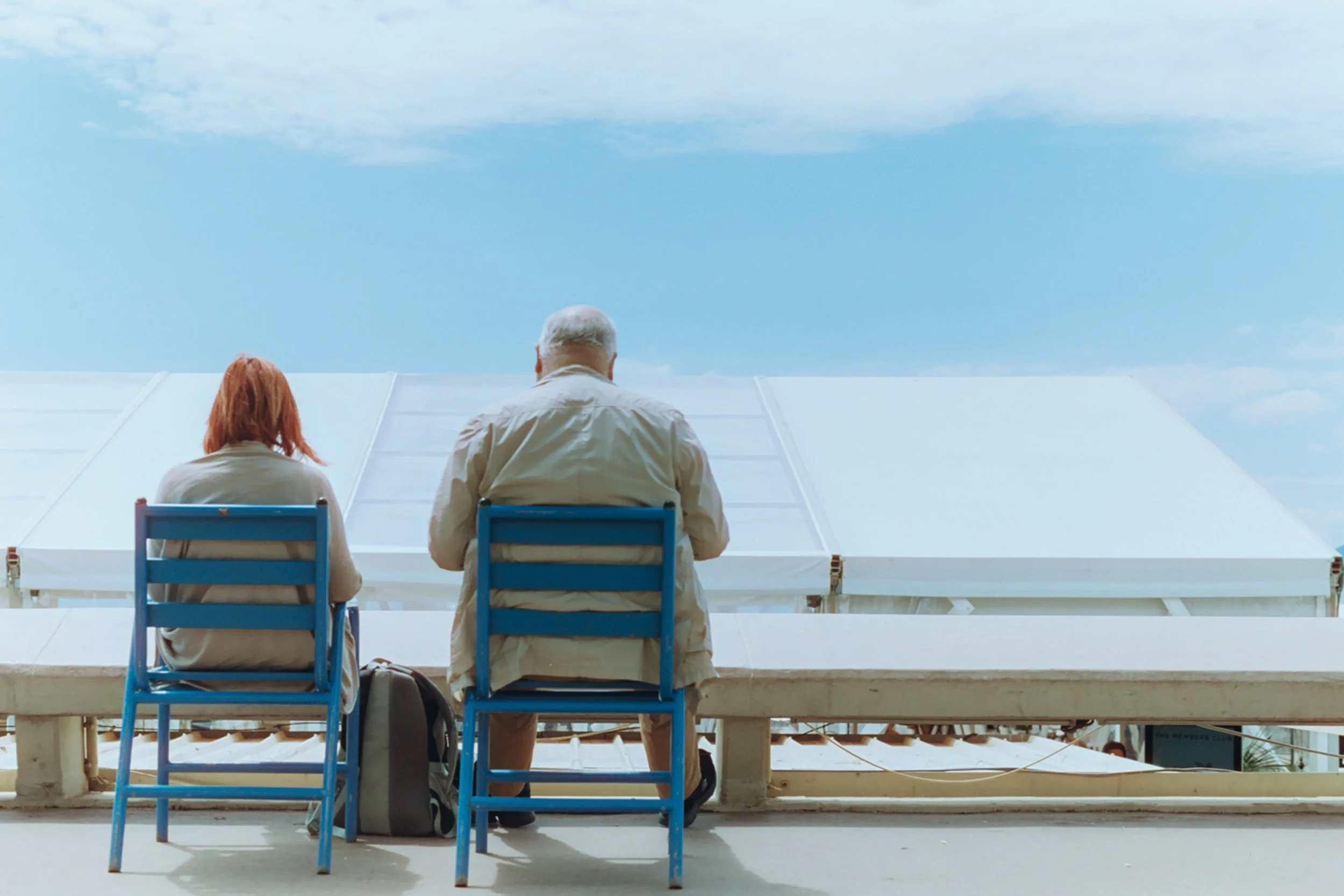 Couple standing close together at night, silhouetted against bright lights in an urban setting